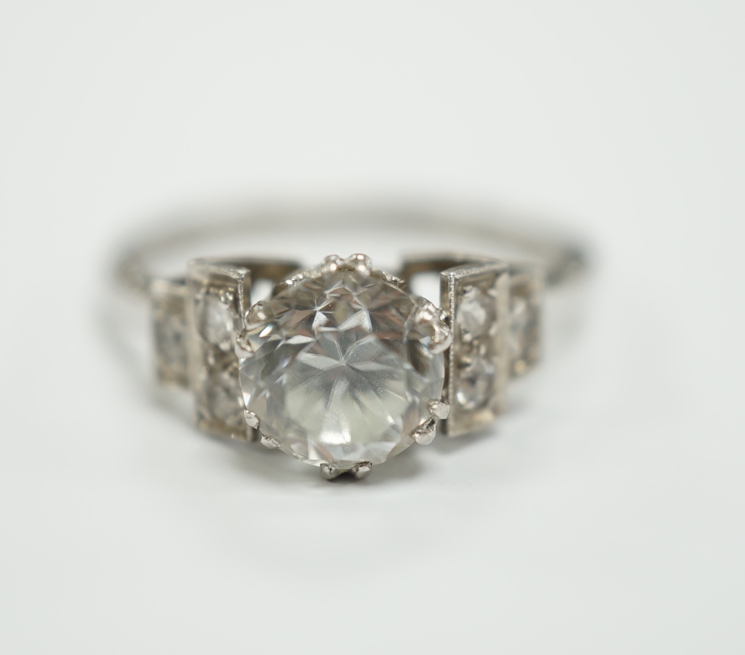 A mid 20th century white metal (stamped plat) and single stone white zircon? set ring, with simulated diamond set shoulders, size N, gross weight 4.3 grams.